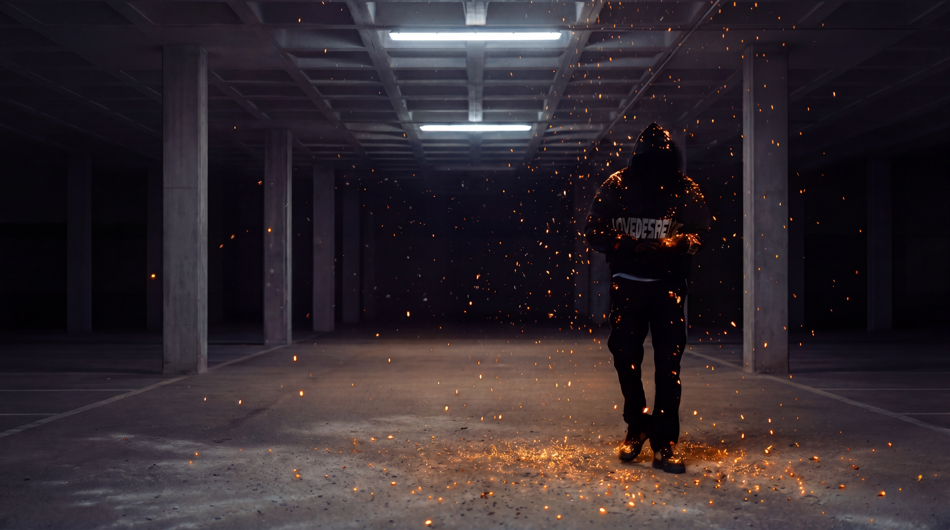 Model walking in full black streetwear outfit with orange fire sparks in underground parking lot